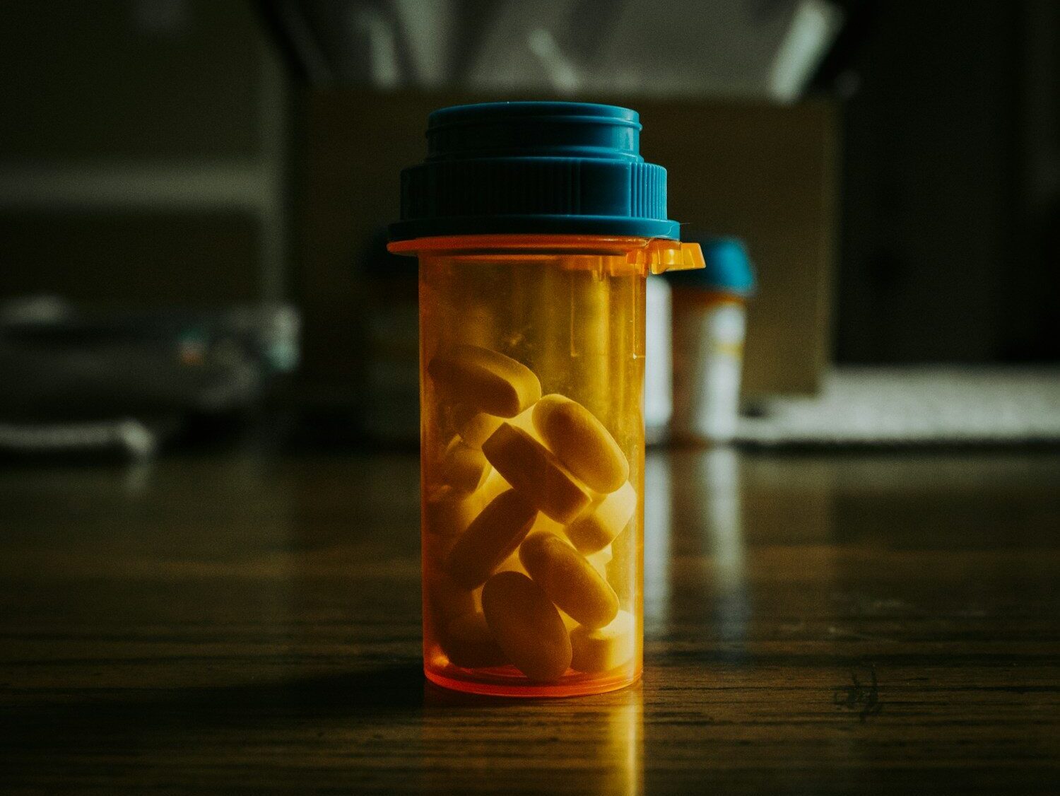 a bottle filled with pills sitting on top of a wooden table